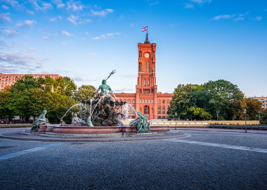 The photo shows the active Neptune Fountain and the Red Town Hall in Berlin in the background.