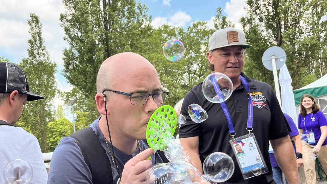 Das Foto zeigt zwei Männer in der Activity Zone. Einer der Männer bläst große Seifenblasen.