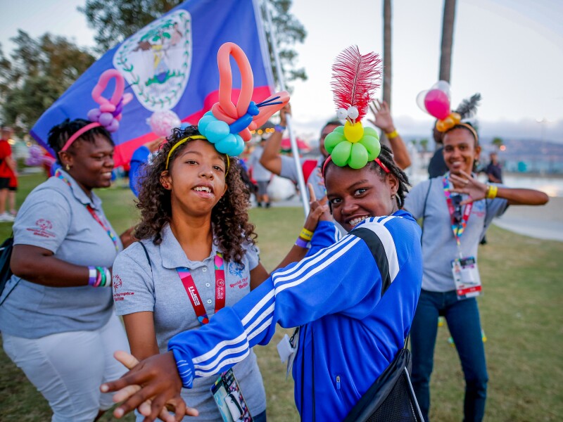 The photo shows five women dancing and wearing homemade headdresses.