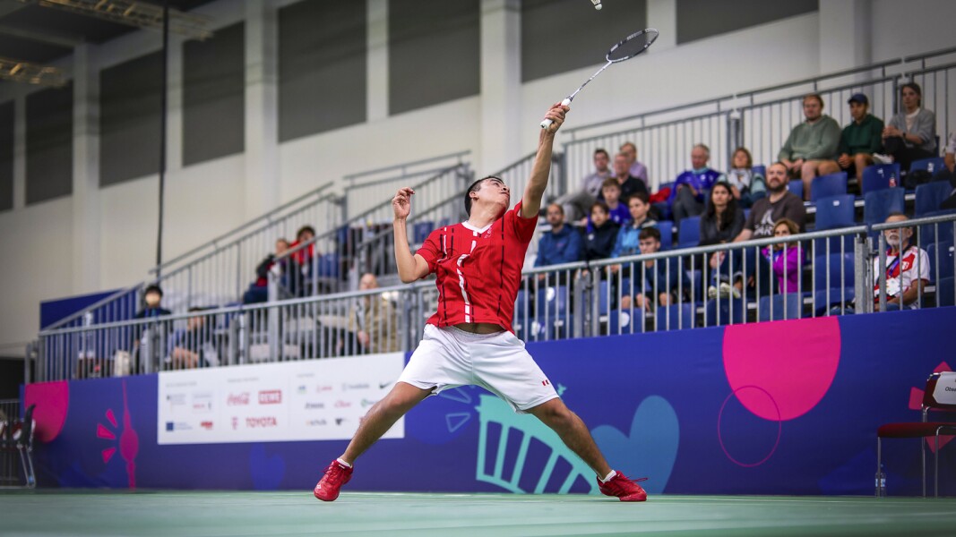 The photo shows a badminton player in action.