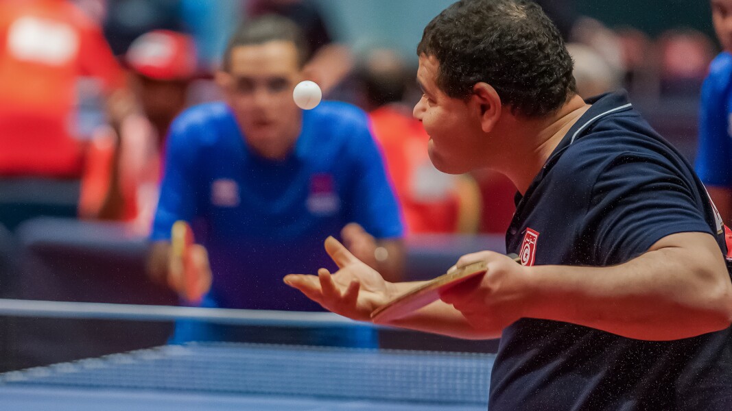 Das Foto zeigt einen Athleten, der gerade beim Tischtennis eine Angabe gibt.