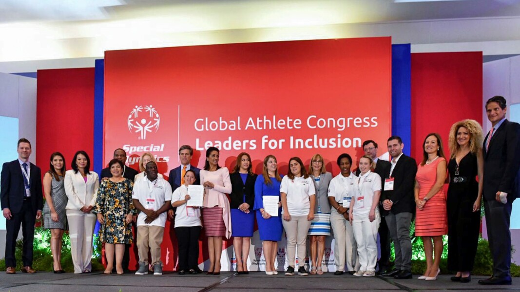 In the photo, several people are standing next to each other. They look joyful.