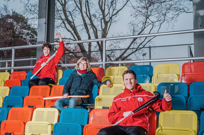 Das Foto zeigt zwei Athleten mit Natascha Keller. Alle halten Hockeyschläger in ihren Händen.