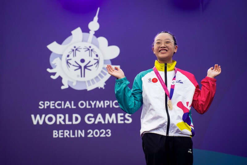 Wai from Hong Kong celebrating the very first gold medal of the special olympics world games 2023 with big smile on her face.