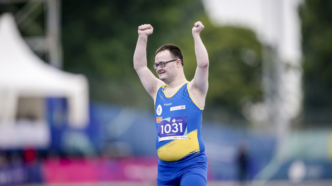 In the photo a track and field athlete is cheering happily.
