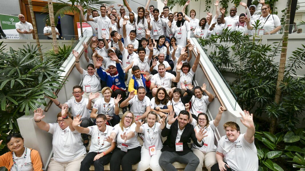 On the photo you can see many participants, they stretch their arms up in the air and laugh