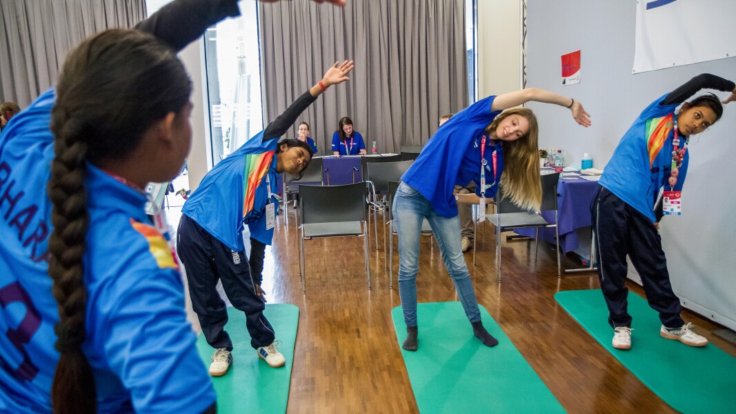Das Foto zeigt eine Gruppe junger Frauen, die im Rahmen des Healthy Athletes Program Dehn- und Streckübungen durchführen.