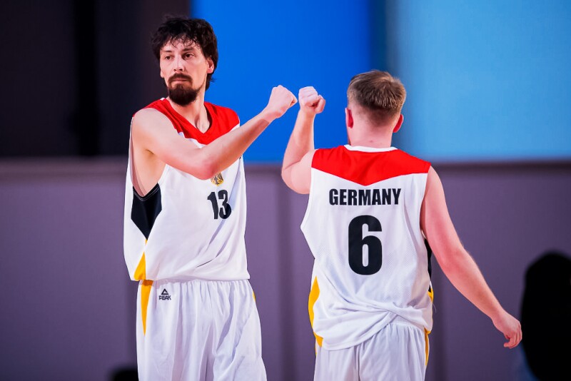 Two Basketball players give each other a fist bump during a match. 