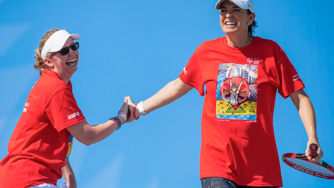 Das Foto zeigt zwei Tennisspielerinnen. Sie freuen sich, lachen und klatschen sich ab.