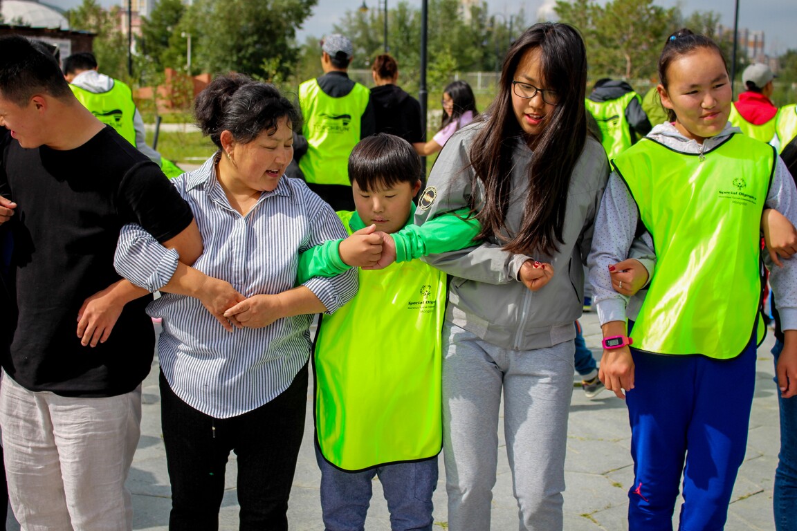 The photo shows families and athletes holding each other by the arms.