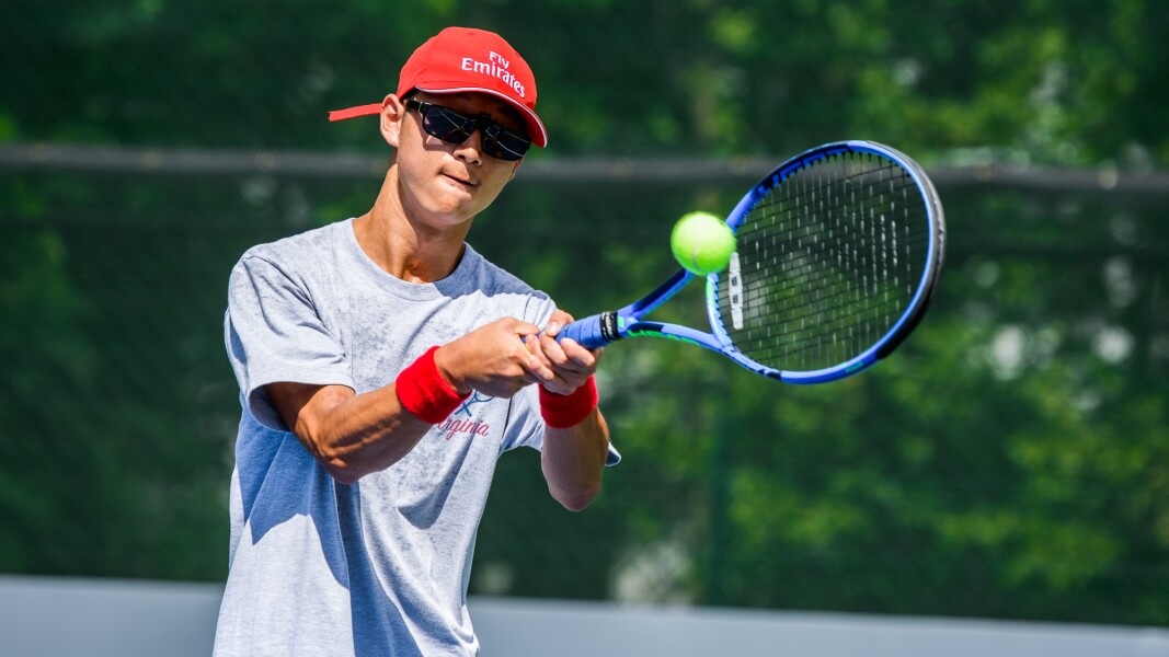 Das Foto zeigt einen Tennisspieler, der gerade mit der Vorhand den Ball zurückspielt.