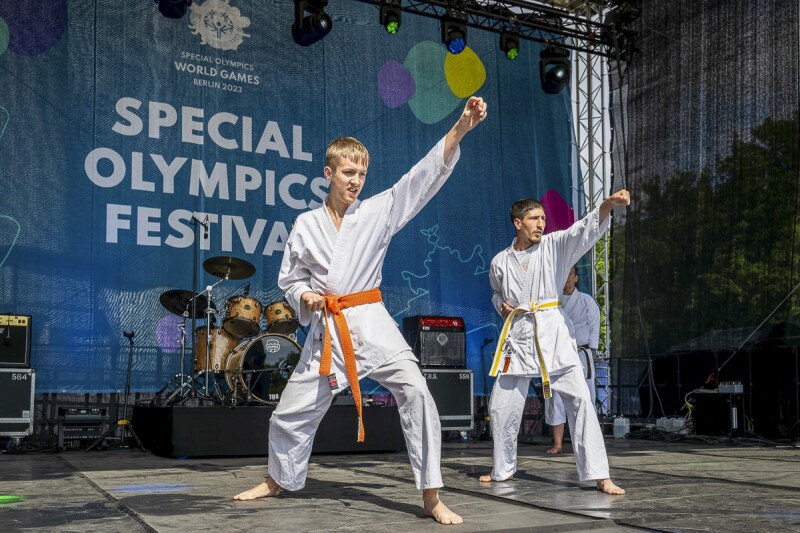 The photo shows two judoka performing on stage. They look concentrated.