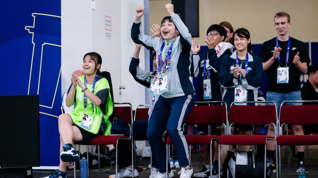 Coaches and teammates cheer on the team.