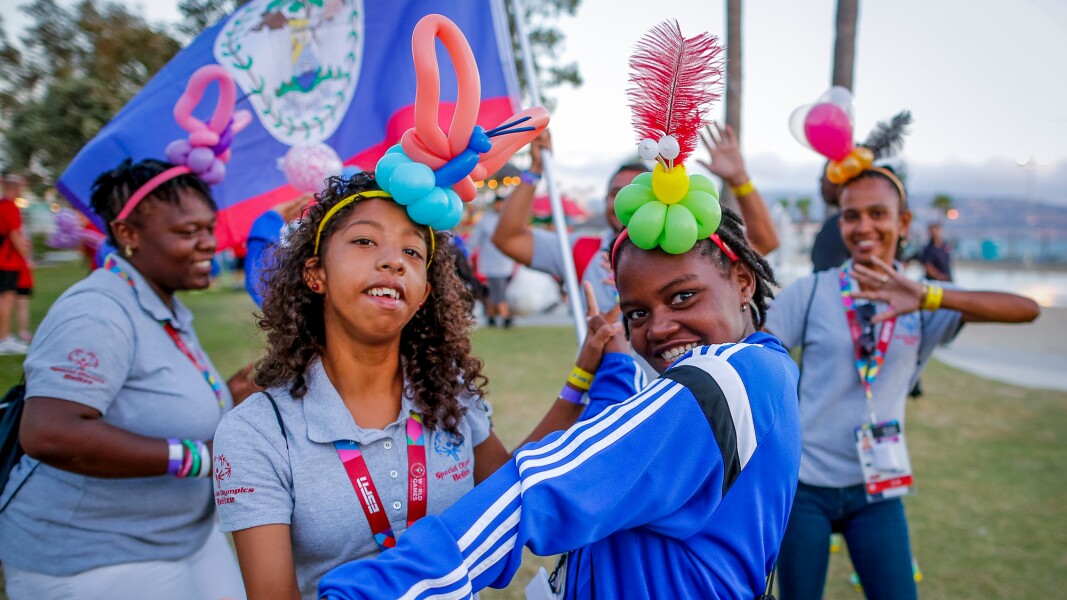 The photo shows five women dancing and wearing homemade headdresses.