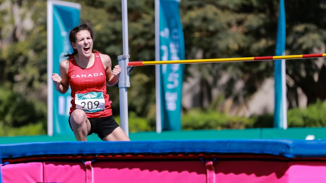 Auf dem Foto jubelt eine Hochspringerin, nachdem sie ihre Höhe erfolgreich übersprungen hat.