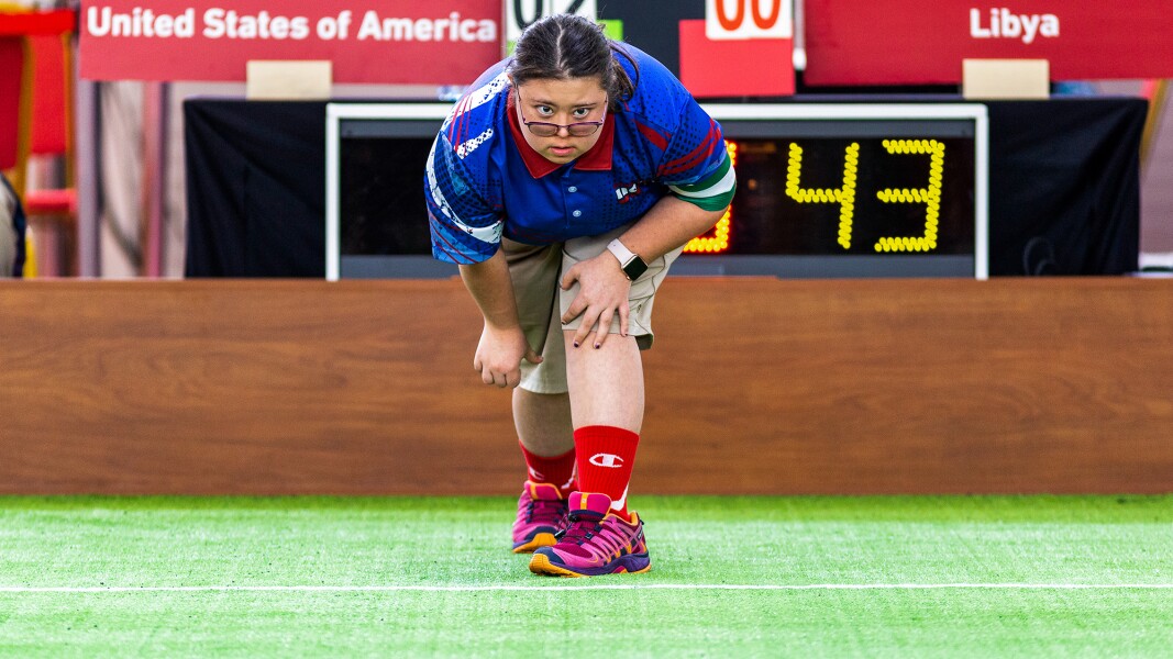 Auf dem Foto schaut eine Boccia-Spielerin konzentriert der Kugel hinterher.