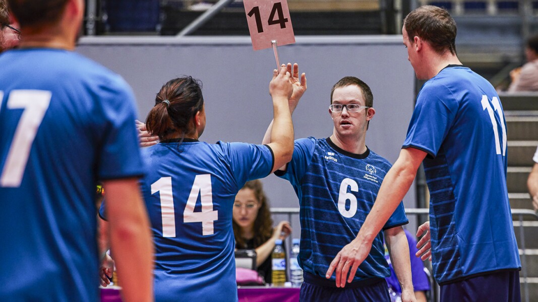Four kazakhs volleyball players dressed in blue making a substitution