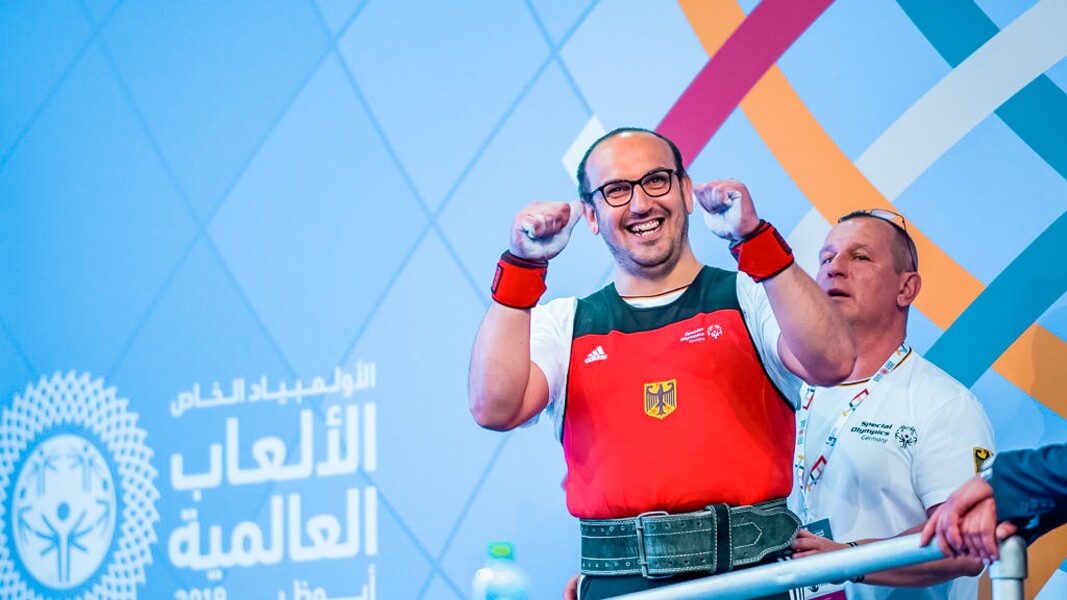 Das Foto zeigt einen Athleten im Kraftdreikampf. Er freut sich, lacht und ballt die Fäuste.
