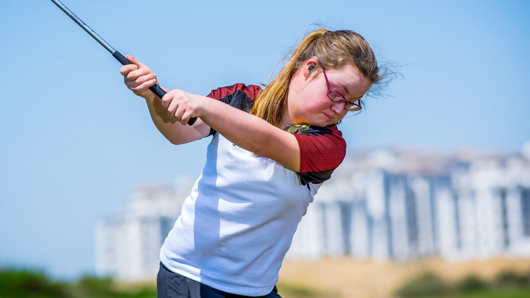 Auf dem Foto ist eine konzentrierte deutsche Golfspielerin zu sehen, die gerade einen Schlag vorbereitet.