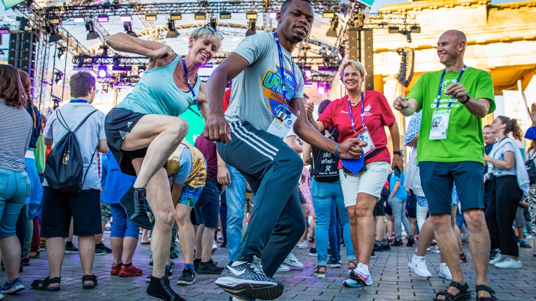 On the photo you see several people dancing wildly in front of the stage.