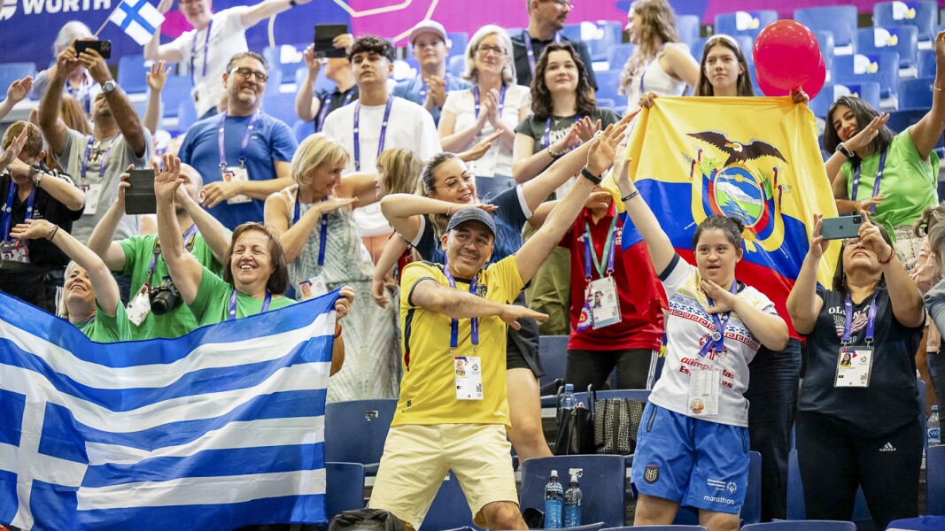 Auf dem Foto sind Fans zu sehen. Sie feuern die Athlet*innen an und freuen sich mit ihnen.