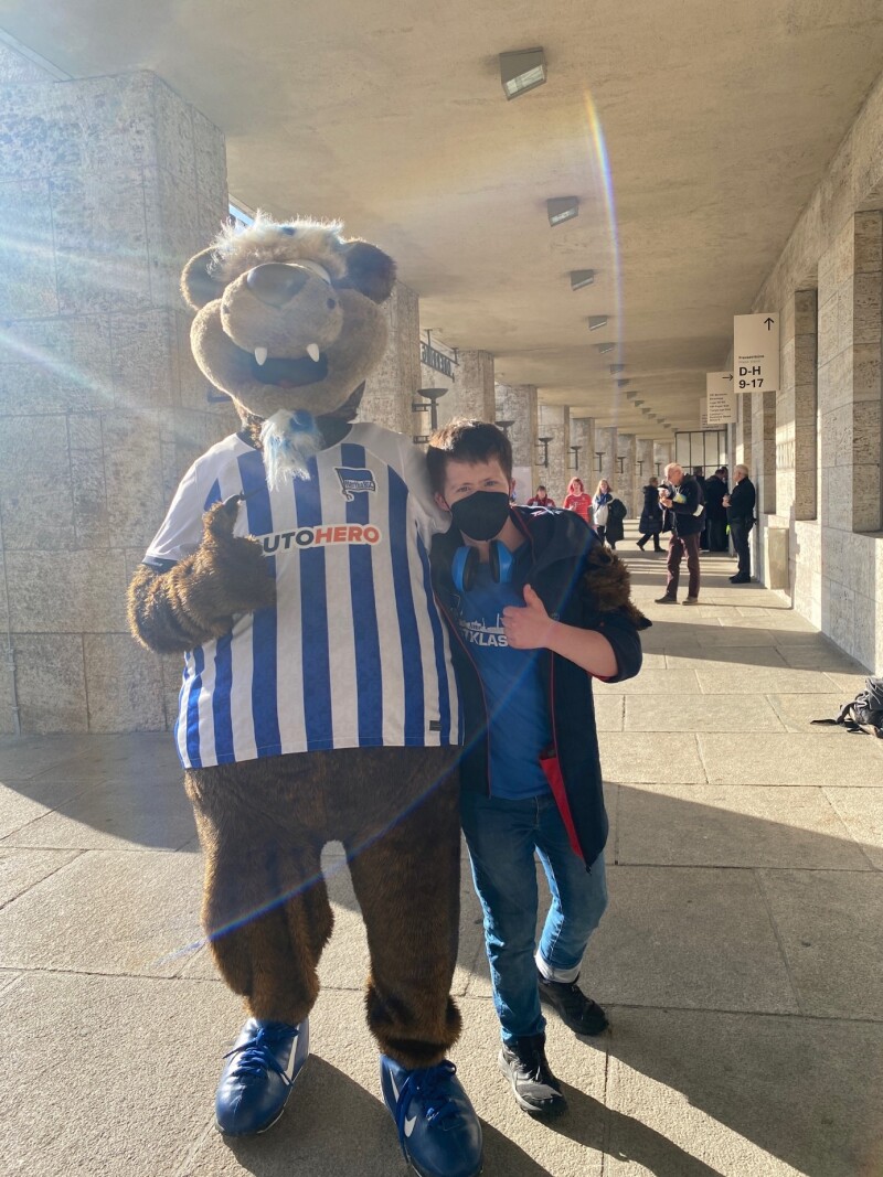 In the photo, Arthur Hackenthal is standing together with Hertha BSC's mascot in front of the Olympic Stadium. Both are pointing their thumbs up.