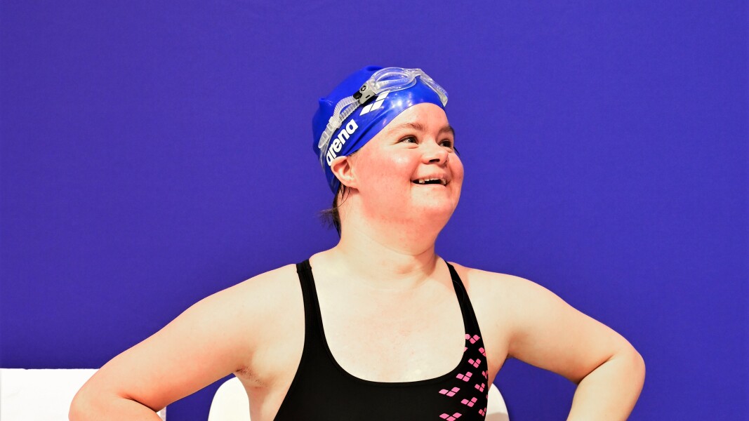 Das Foto zeigt eine Schwimmerin. Sie lächelt in die Kamera.
