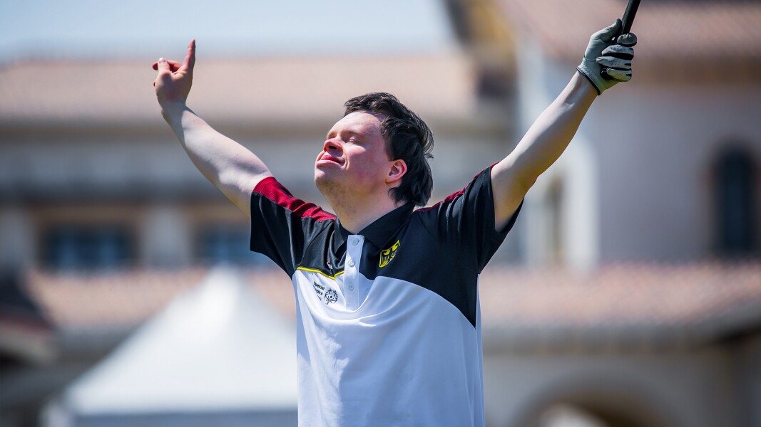 Ein Golfspieler ist auf dem Foto mit den Armen nach oben, geschlossenen Augen und in sehr glücklicher Pose.